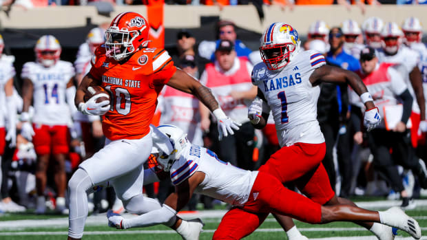 Oct 14, 2023; Stillwater, Oklahoma, USA; Oklahoma State's Rashod Owens (10) is tripped up by Kansas Jayhawks s O.J. Burroughs (5) in the first quarter at Boone Pickens Stadium. Mandatory Credit: Nathan J. Fish-USA TODAY Sports
